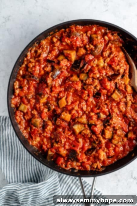 Vegan meat and eggplant cooking in tomato sauce.