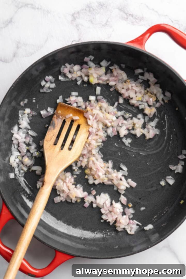 Close-up of chopped red onions gently stirring and cooking in a skillet with olive oil, starting to soften and brown.