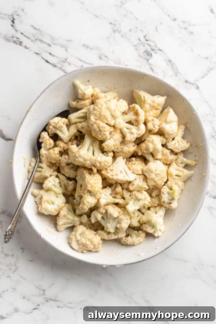 This vegan butter cauliflower starts by marinating the cauliflower in coconut and spices, making it extra delicious. Better than takeout! Overhead view of cauliflower marinating with spices and coconut milk