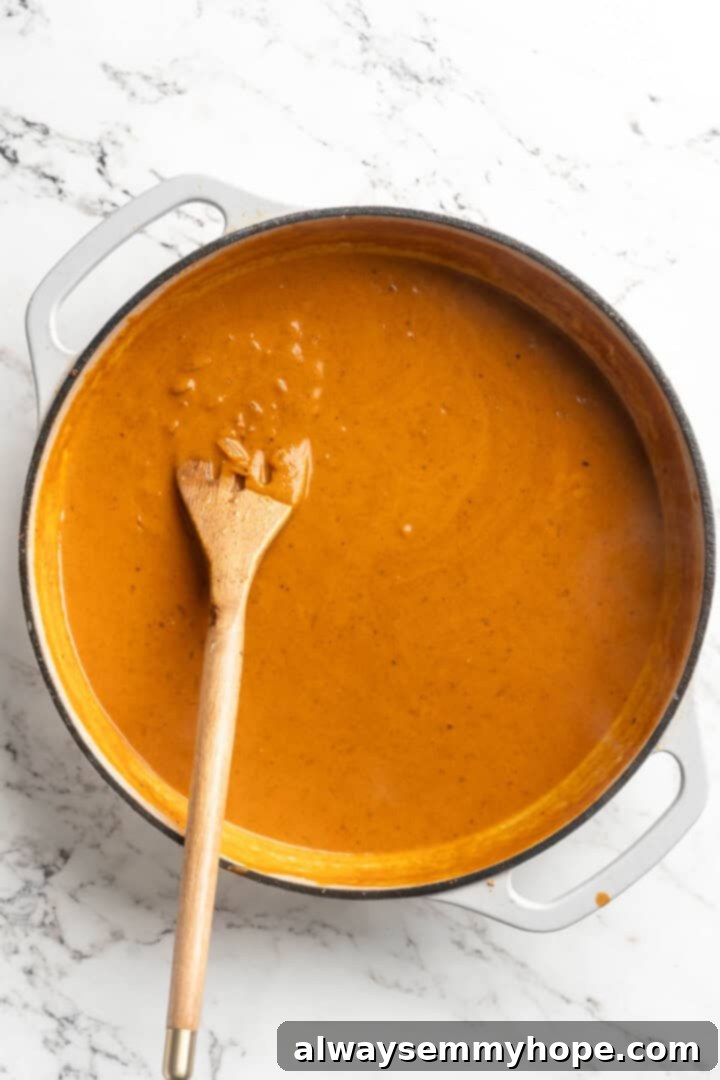 This vegan butter cauliflower starts by marinating the cauliflower in coconut and spices, making it extra delicious. Better than takeout! Overhead view of vegan butter sauce in pan