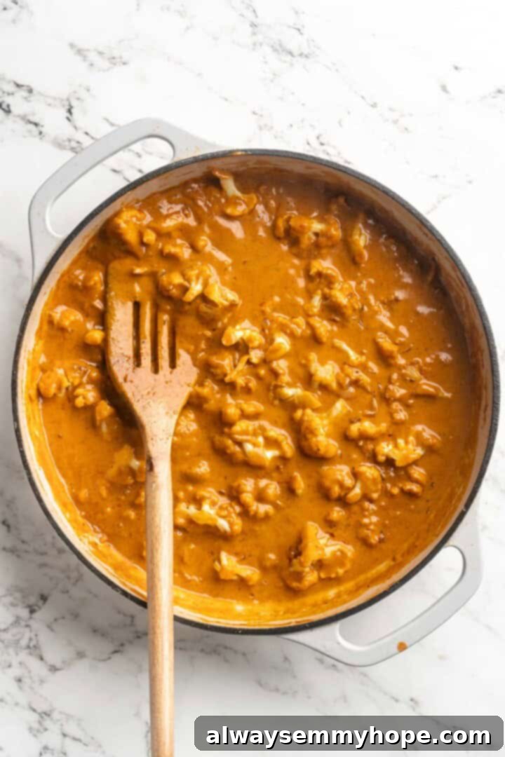 This vegan butter cauliflower starts by marinating the cauliflower in coconut and spices, making it extra delicious. Better than takeout! Overhead view of vegan butter cauliflower in pan