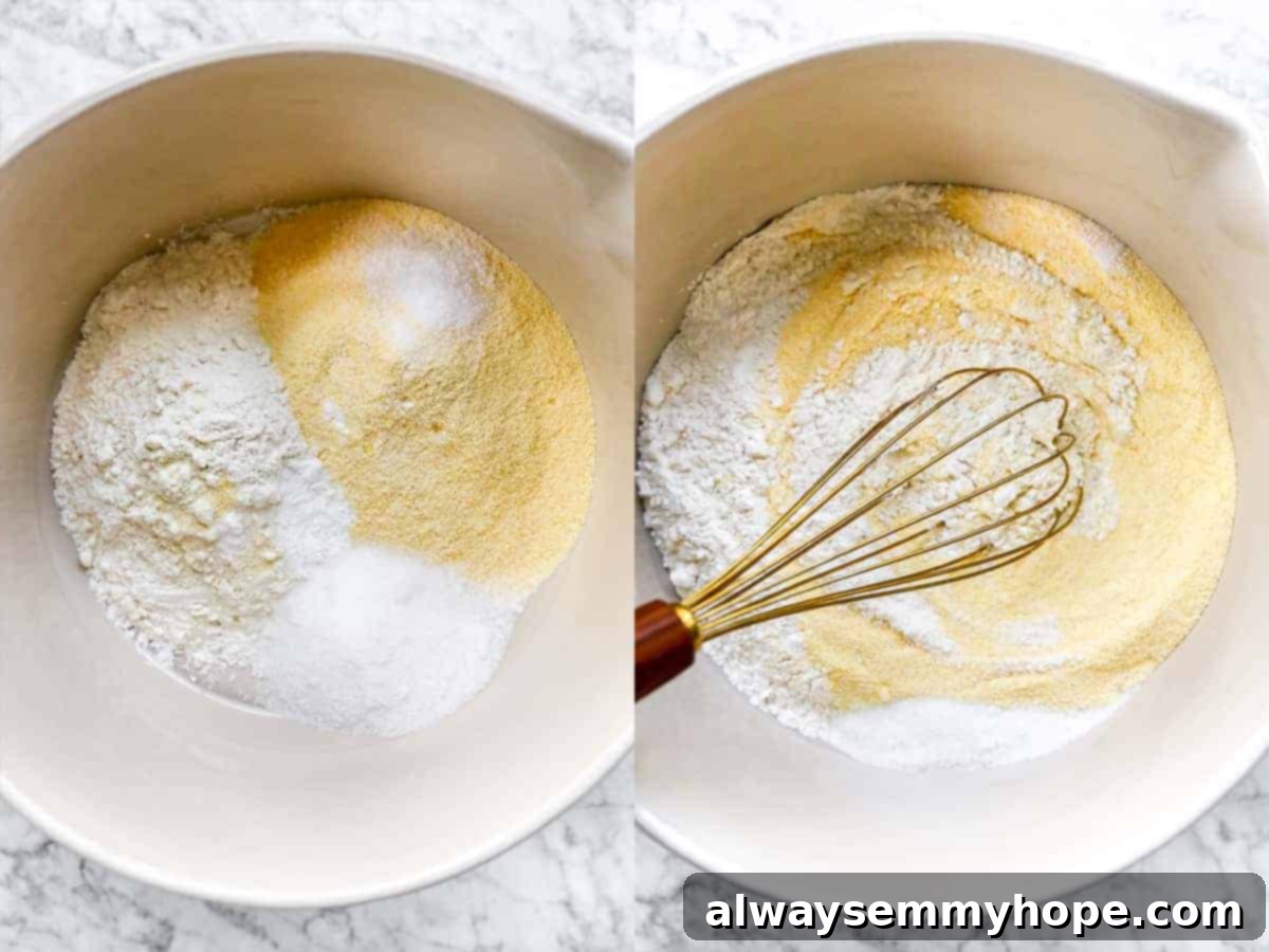 A metal whisk in a bowl of dry ingredients for cornbread, showing the textures of cornmeal and flour.
