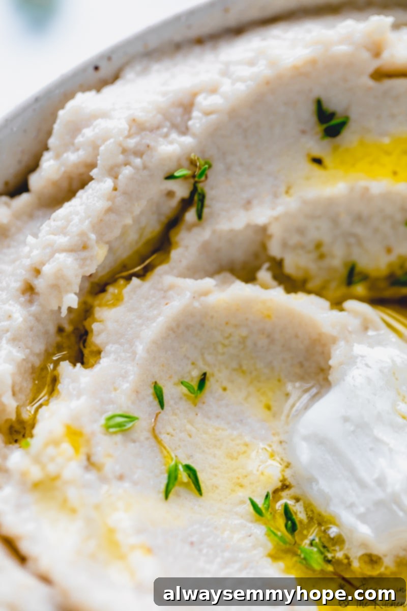 Close up of mashed cauliflower in a bowl, showing its smooth texture.