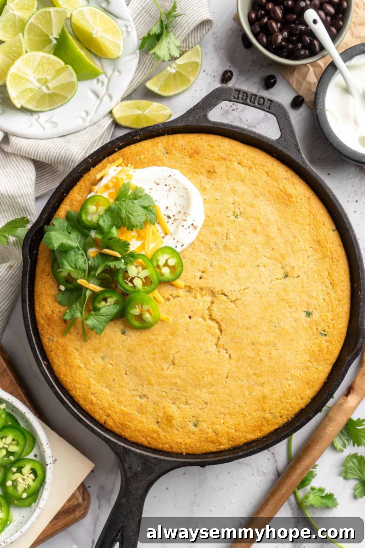 This vegan chili cornbread casserole is one of the BEST casseroles ever! The secret? Sweet, crispy cornbread baked on top of delicious chili. Overhead view of a portion of vegan chili cornbread casserole on a plate, garnished with fresh cilantro and vegan sour cream