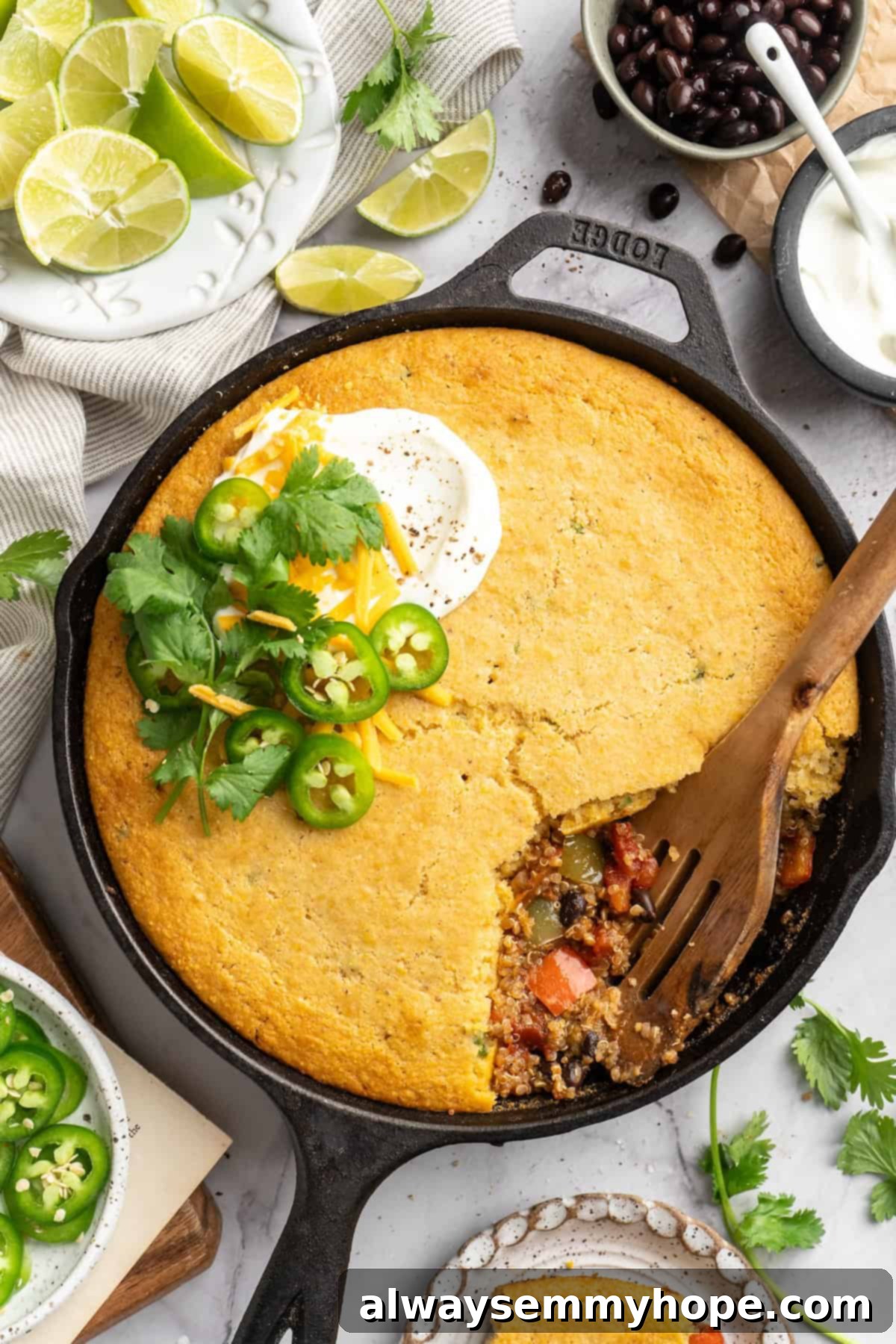 This vegan chili cornbread casserole is one of the BEST casseroles ever! The secret? Sweet, crispy cornbread baked on top of delicious chili. Overhead view of chili cornbread casserole in a skillet, beautifully baked and ready to be served