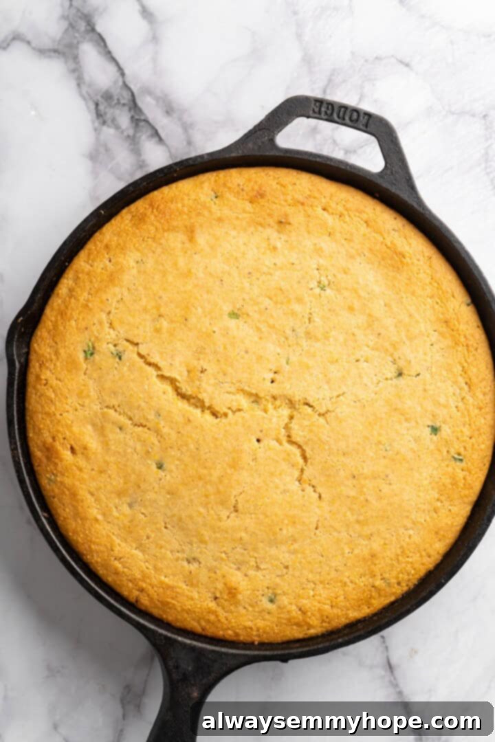 This vegan chili cornbread casserole is one of the BEST casseroles ever! The secret? Sweet, crispy cornbread baked on top of delicious chili. Overhead view of the vegan chili cornbread casserole in a skillet, freshly baked to a golden brown
