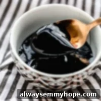 Easy Homemade Balsamic Glaze 2 A bowl of balsamic glaze with a spoon over it.