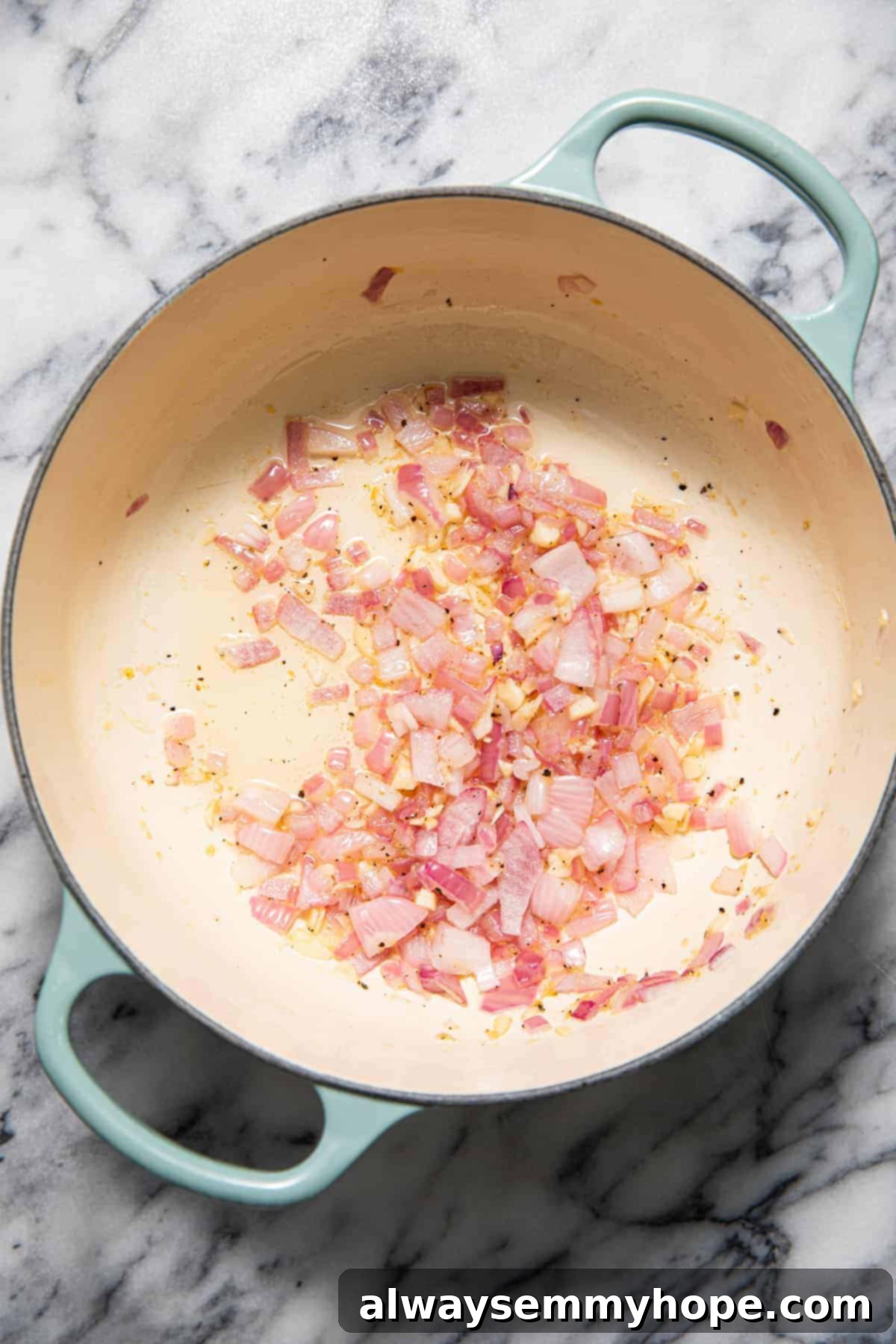 Sautéing onions and garlic in a pan.