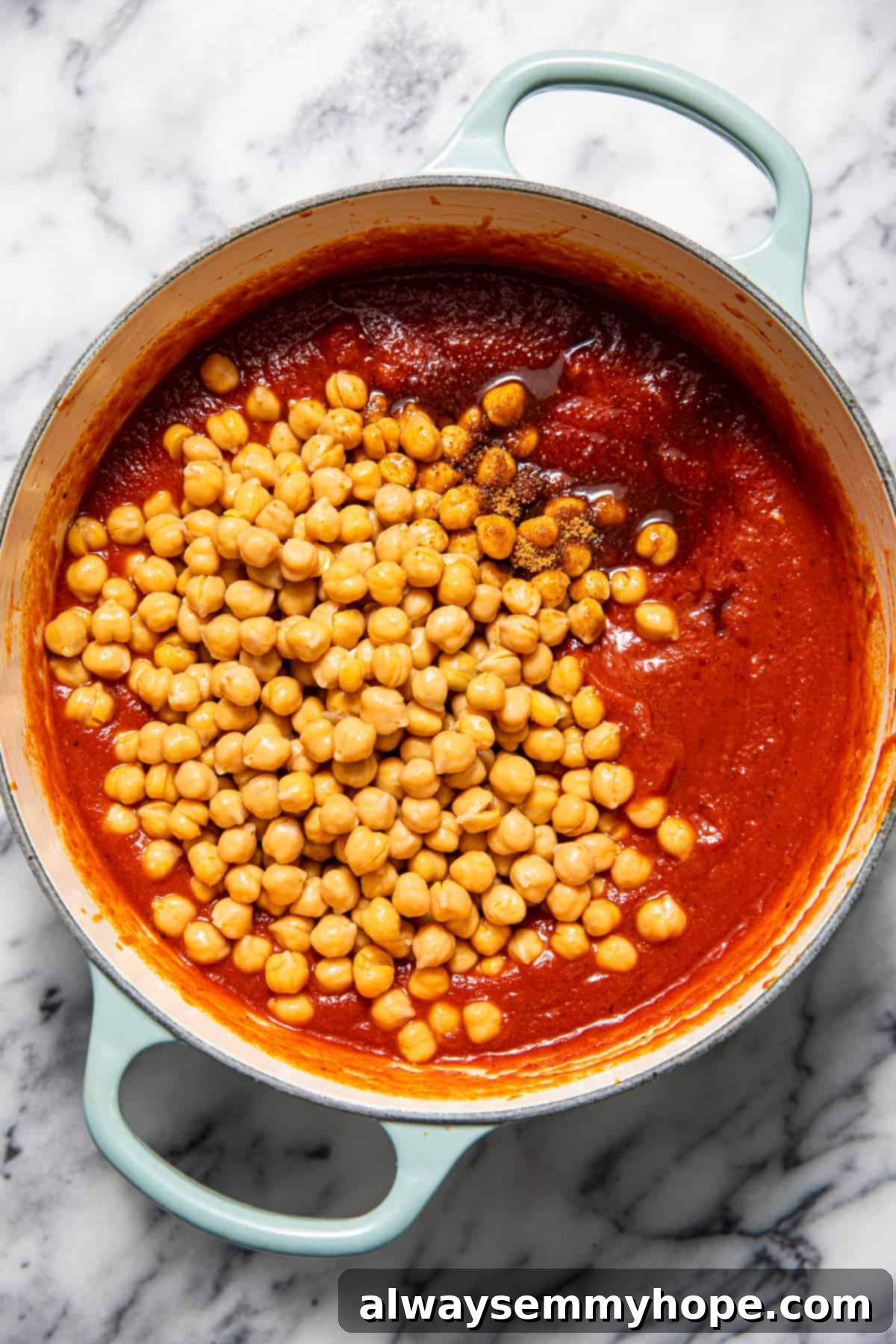 Chickpeas in a pan of tomato sauce.
