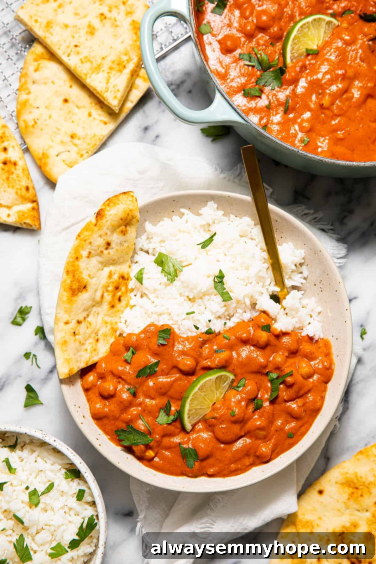 Plate of chickpea curry with rice and naan.