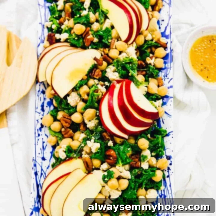 80+ Vegan Thanksgiving Feast Recipes 34 A vibrant kale, apple, and chickpea salad with vegan feta, dressed and ready to be served.