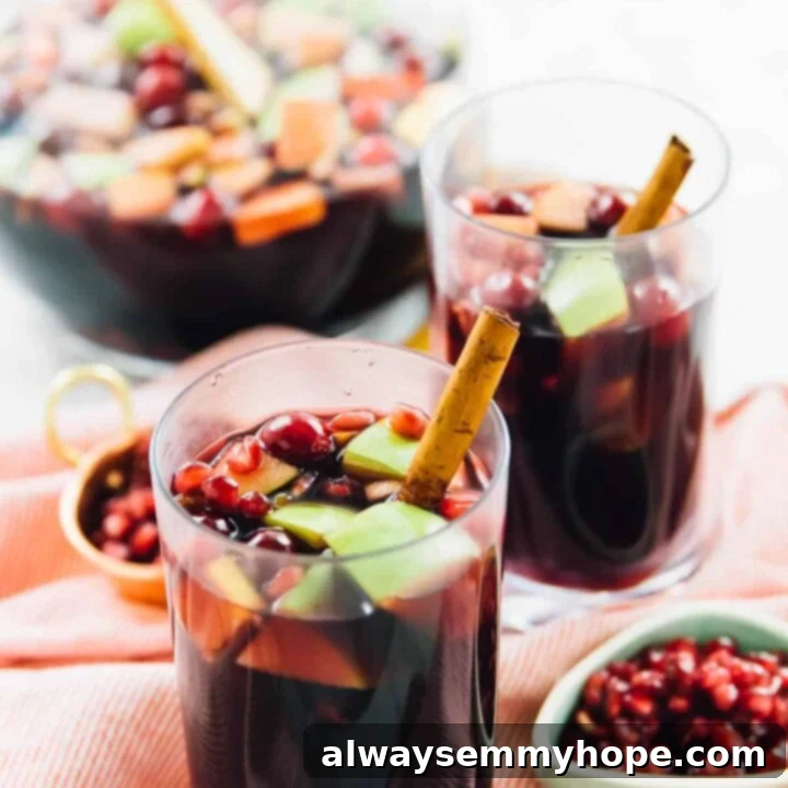 80+ Vegan Thanksgiving Feast Recipes 78 A festive pitcher of red wine apple cider fall sangria, brimming with sliced apples, cranberries, and citrus.
