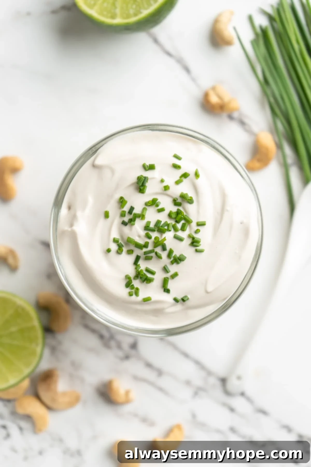 This vegan sour cream recipe is thick, creamy and tangy—and you only need 5 ingredients! Use it all the ways you use traditional sour cream. Overhead view of vegan sour cream in jar with chives