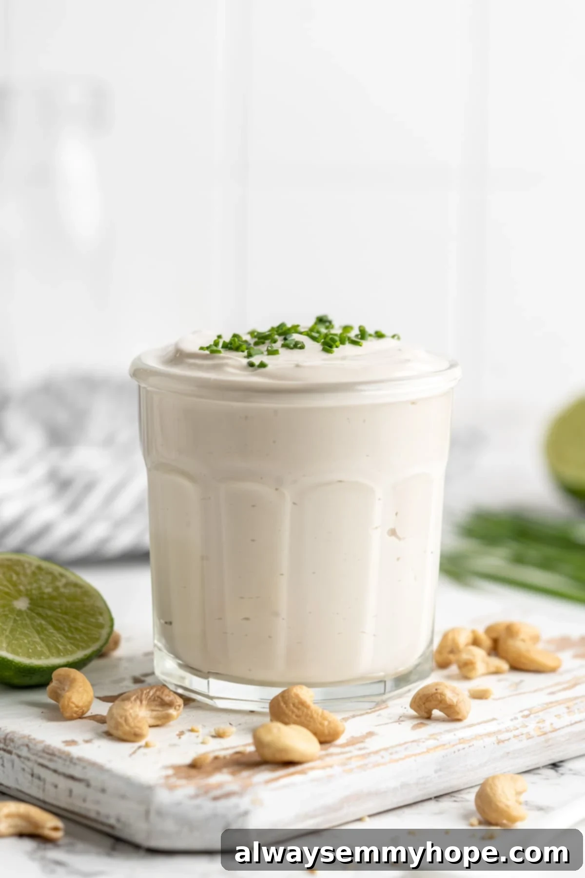 This vegan sour cream recipe is thick, creamy and tangy—and you only need 5 ingredients! Use it all the ways you use traditional sour cream. Vegan sour cream in jar with chives on top
