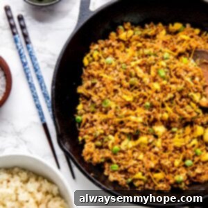 Vibrant vegan cauliflower fried rice in a skillet, ready to serve, with chopsticks nearby.