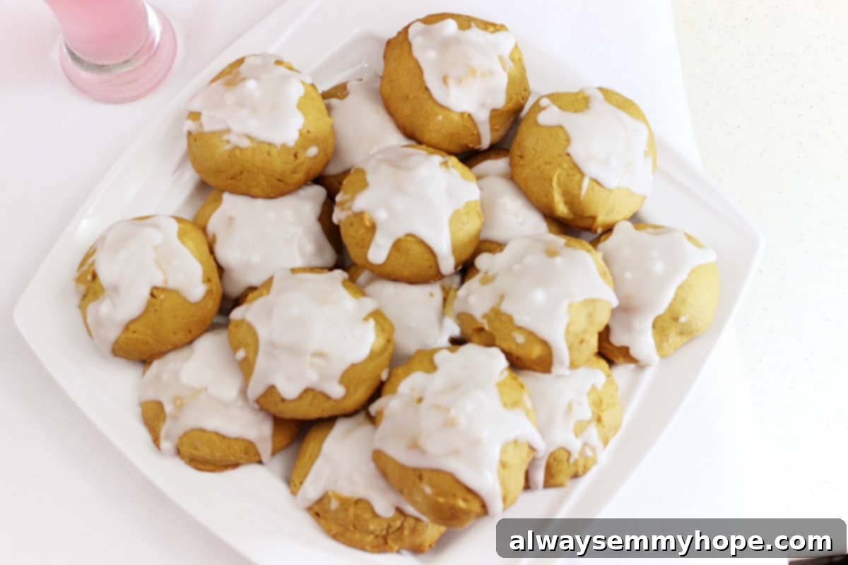 Top down shot of beautifully iced pumpkin cookies arranged on a pristine white dish.