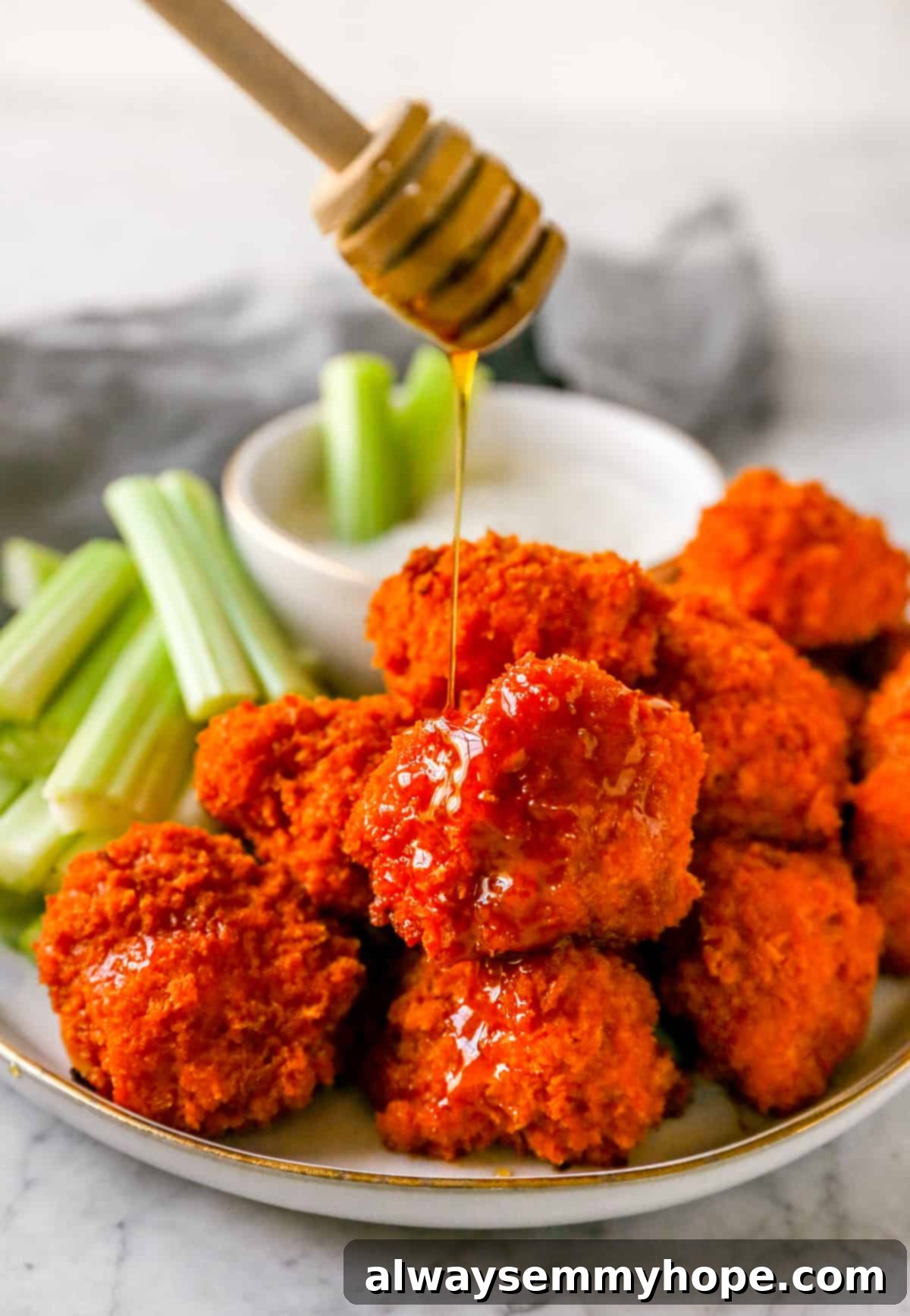 Score Big with 30 Vegan Super Bowl Recipes 2 Crispy Buffalo Cauliflower Wings on a plate, garnished with green onions, perfect for a vegan Super Bowl party.