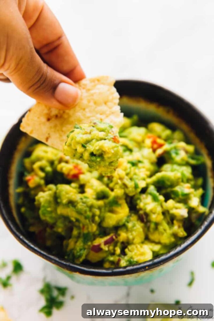 Score Big with 30 Vegan Super Bowl Recipes 13 Fresh and Easy Guacamole in a bowl with tortilla chips.