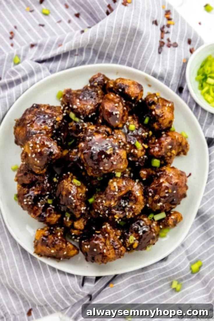Score Big with 30 Vegan Super Bowl Recipes 16 General Tso Cauliflower Wings glistening with sauce in a bowl.
