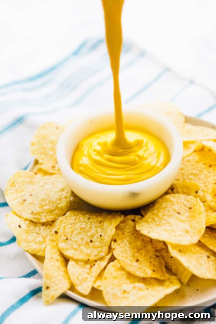 Score Big with 30 Vegan Super Bowl Recipes 19 Creamy Vegan Cheese Sauce in a bowl, ready for dipping.