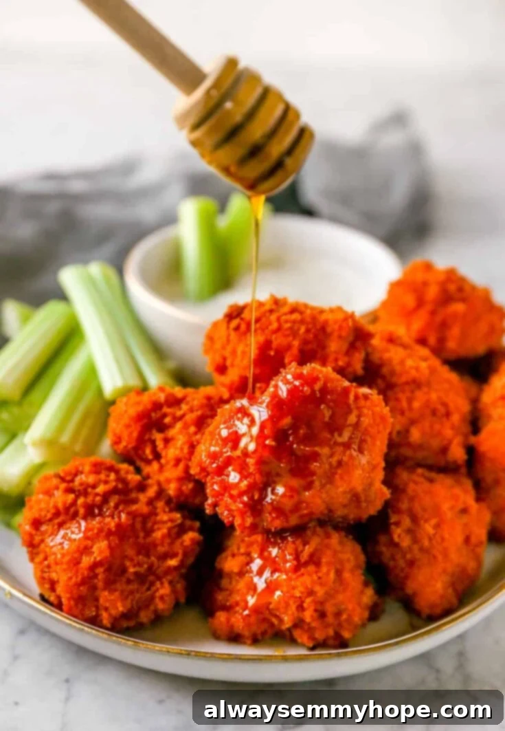 Score Big with 30 Vegan Super Bowl Recipes 4 Crispy Buffalo Cauliflower Wings on a platter with celery sticks and dip.
