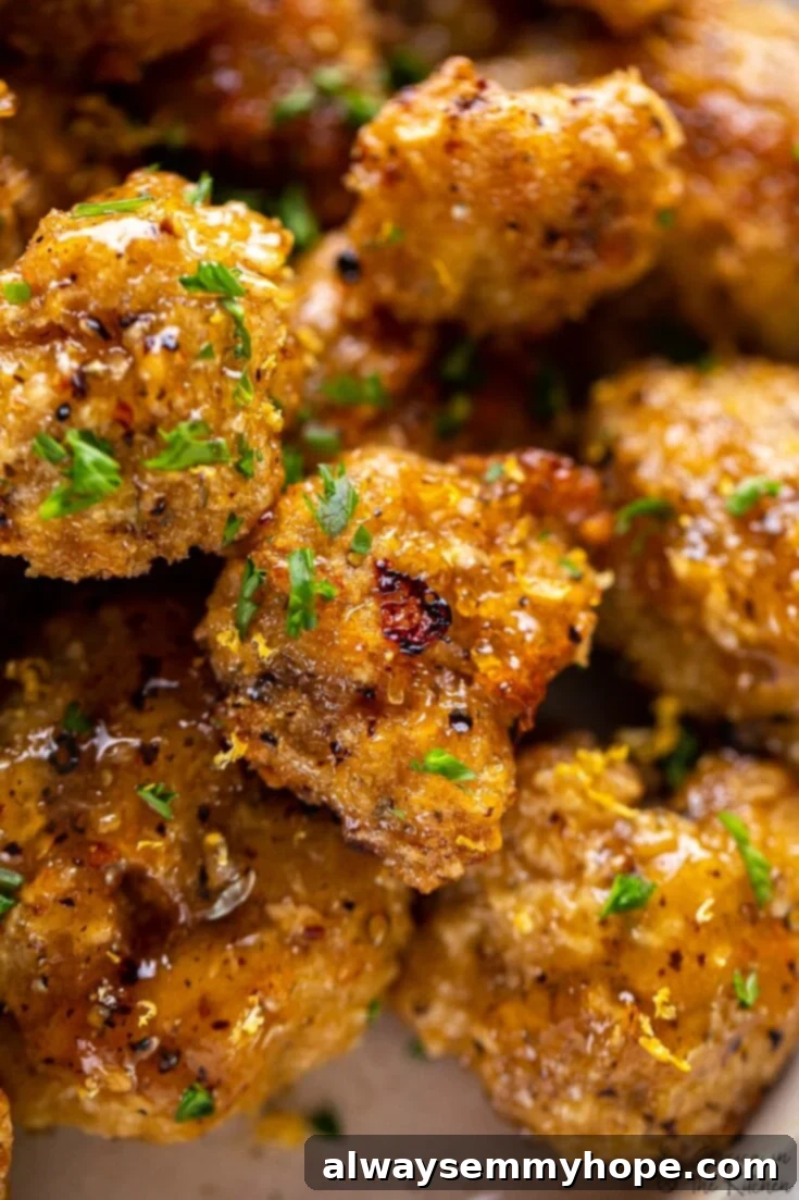 Score Big with 30 Vegan Super Bowl Recipes 10 Lemon Pepper Cauliflower Wings on a serving platter with lemon wedges.