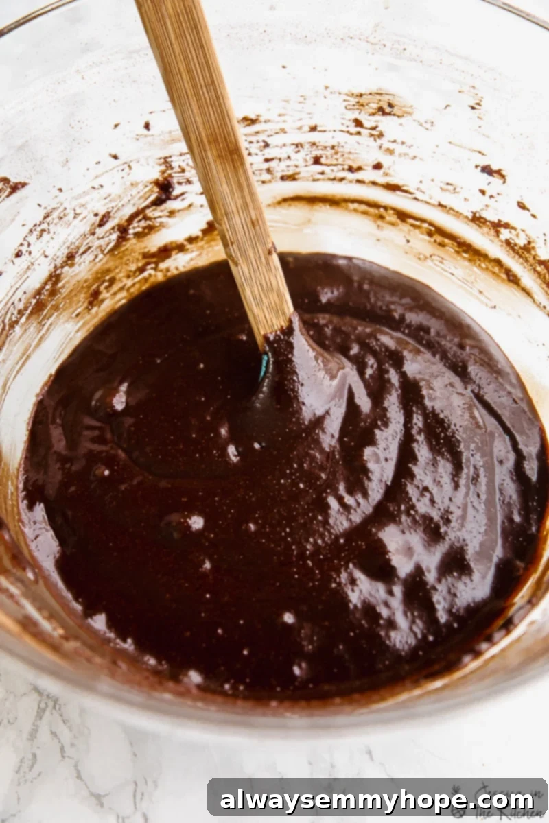 One Bowl Fudgy Vegan Gluten Free Almond Flour Brownies 3 Smooth, rich vegan almond flour brownie batter in a bowl with a spoon.