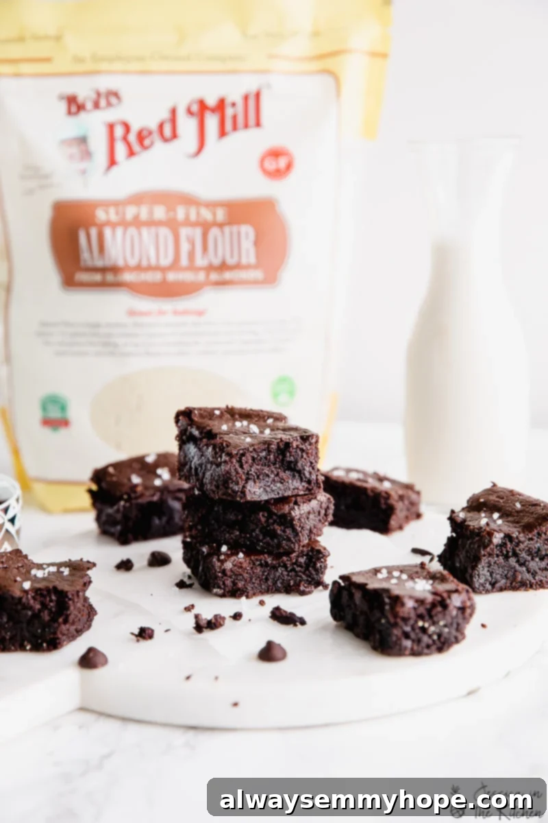 One Bowl Fudgy Vegan Gluten Free Almond Flour Brownies 4 Vegan Almond Flour Brownies stacked near a bag of Bob's Red Mill almond flour.