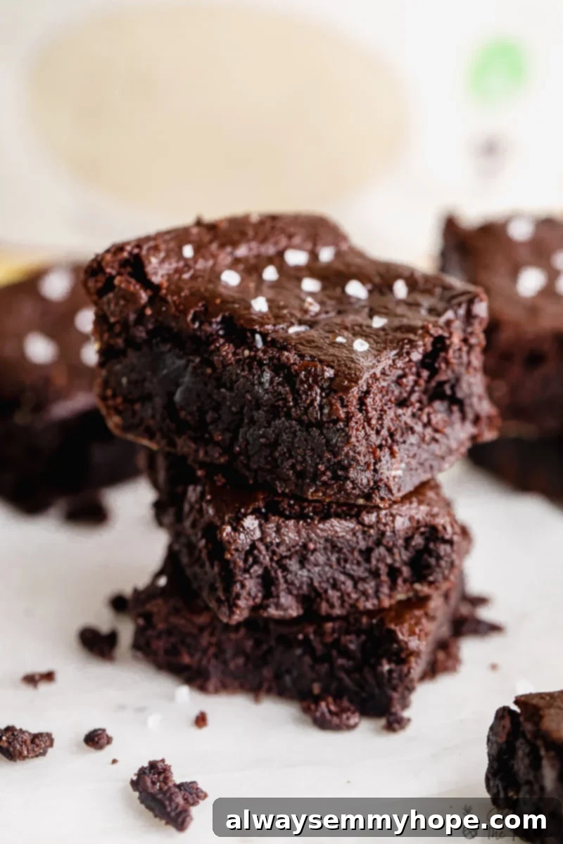 One Bowl Fudgy Vegan Gluten Free Almond Flour Brownies 6 Close-up of fudgy vegan almond flour brownies stacked with sea salt flakes.