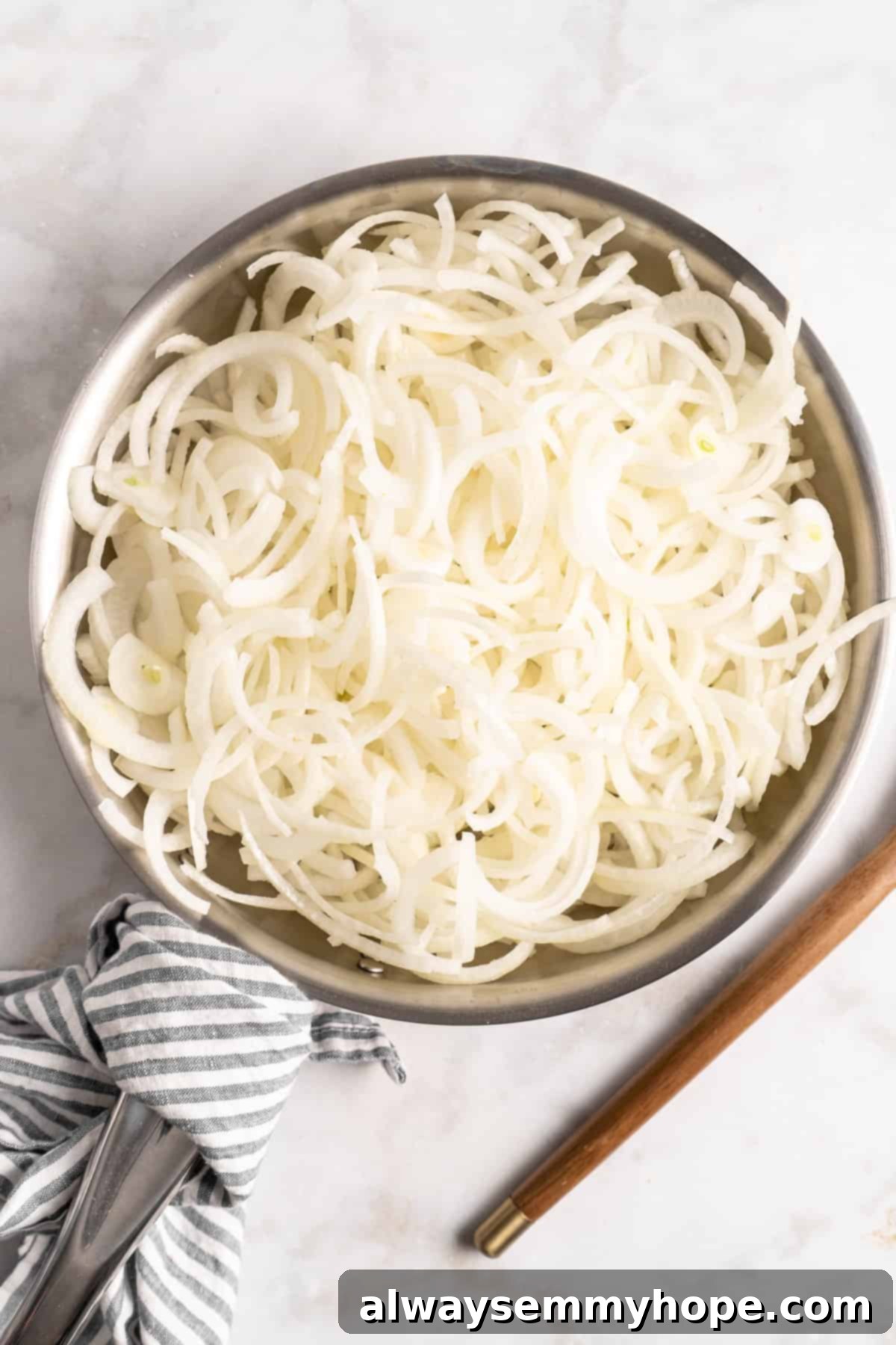 Learn how to caramelize onions the right way for sweet, deeply browned, jammy onions to add to your favorite meals and recipes! Thinly sliced raw yellow onions in a large skillet, ready for cooking