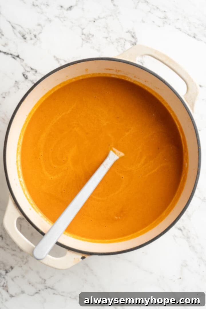 Overhead view of the pureed creamy tomato soup in the pot, now smooth and ready for the final touches.