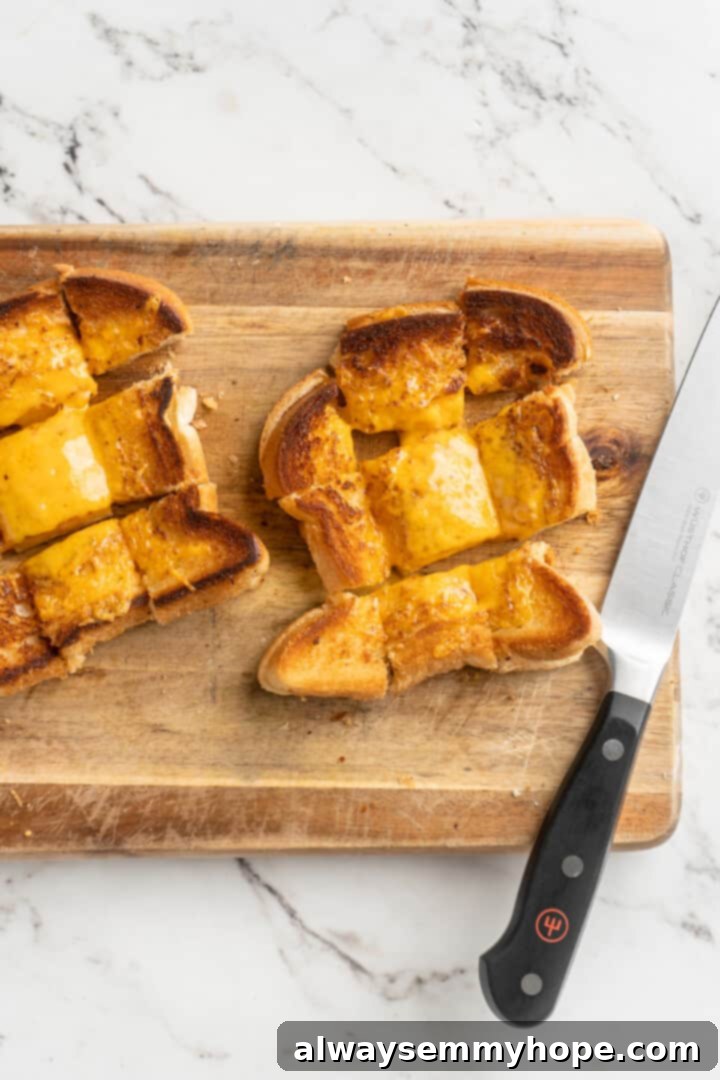 Overhead view of a cooked grilled cheese sandwich, cut into small, perfect squares, ready to be used as croutons.