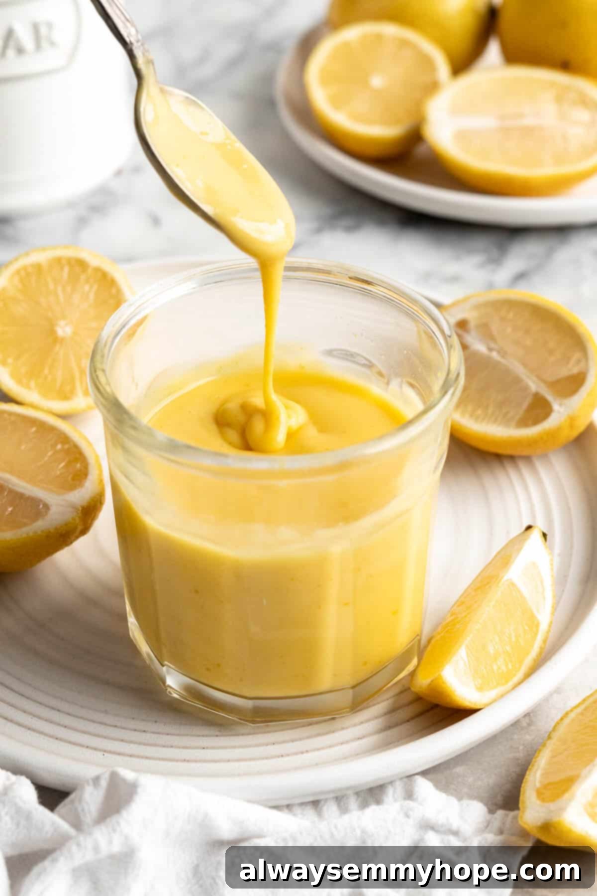 Spoon drizzling vegan lemon curd back into jar