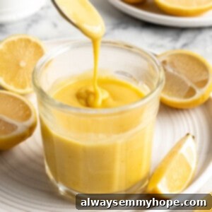 Spoon drizzling vegan lemon curd back into jar