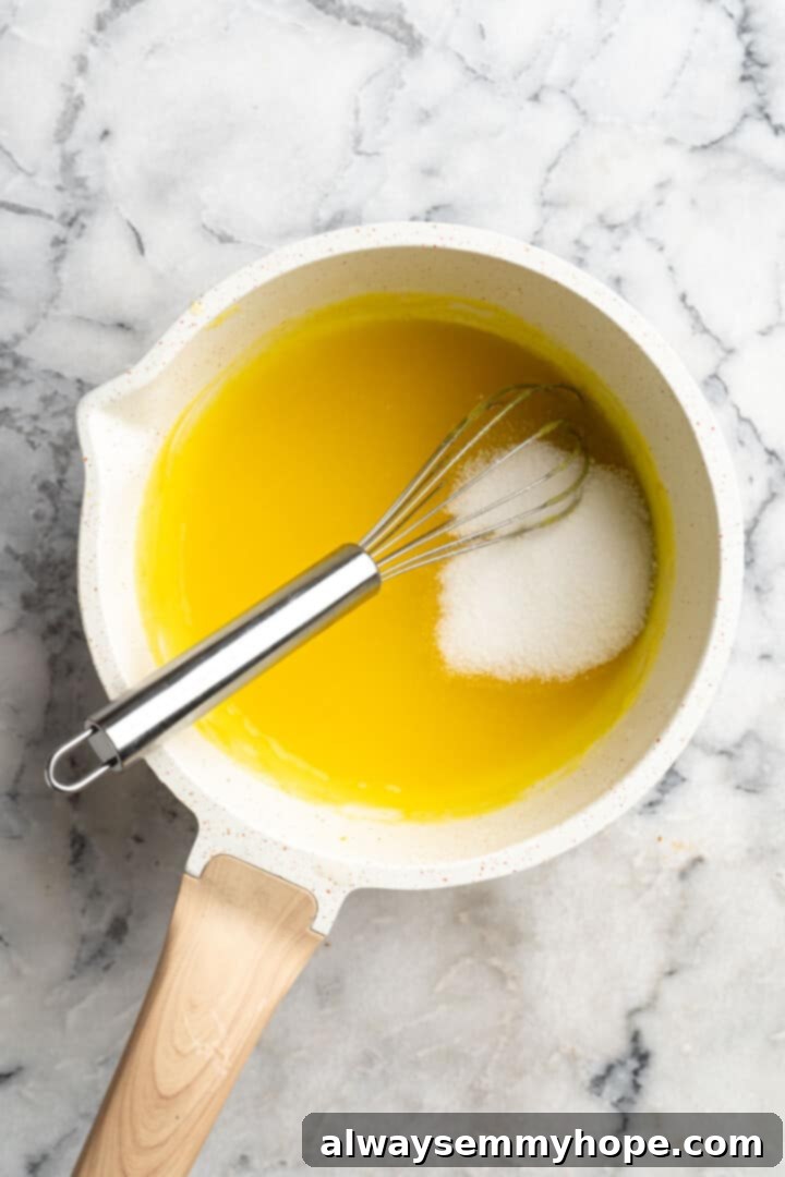 Overhead view of sugar added to saucepan of vegan lemon curd