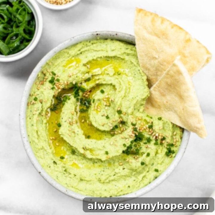 25 Festive Vegan Recipes for St. Patrick's Day 19 Creamy Avocado & Edamame Hummus in a bowl, garnished with herbs and served with pita bread.