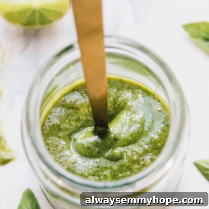 25 Festive Vegan Recipes for St. Patrick's Day 9 Vibrant green basil pesto in a small bowl with fresh basil leaves.