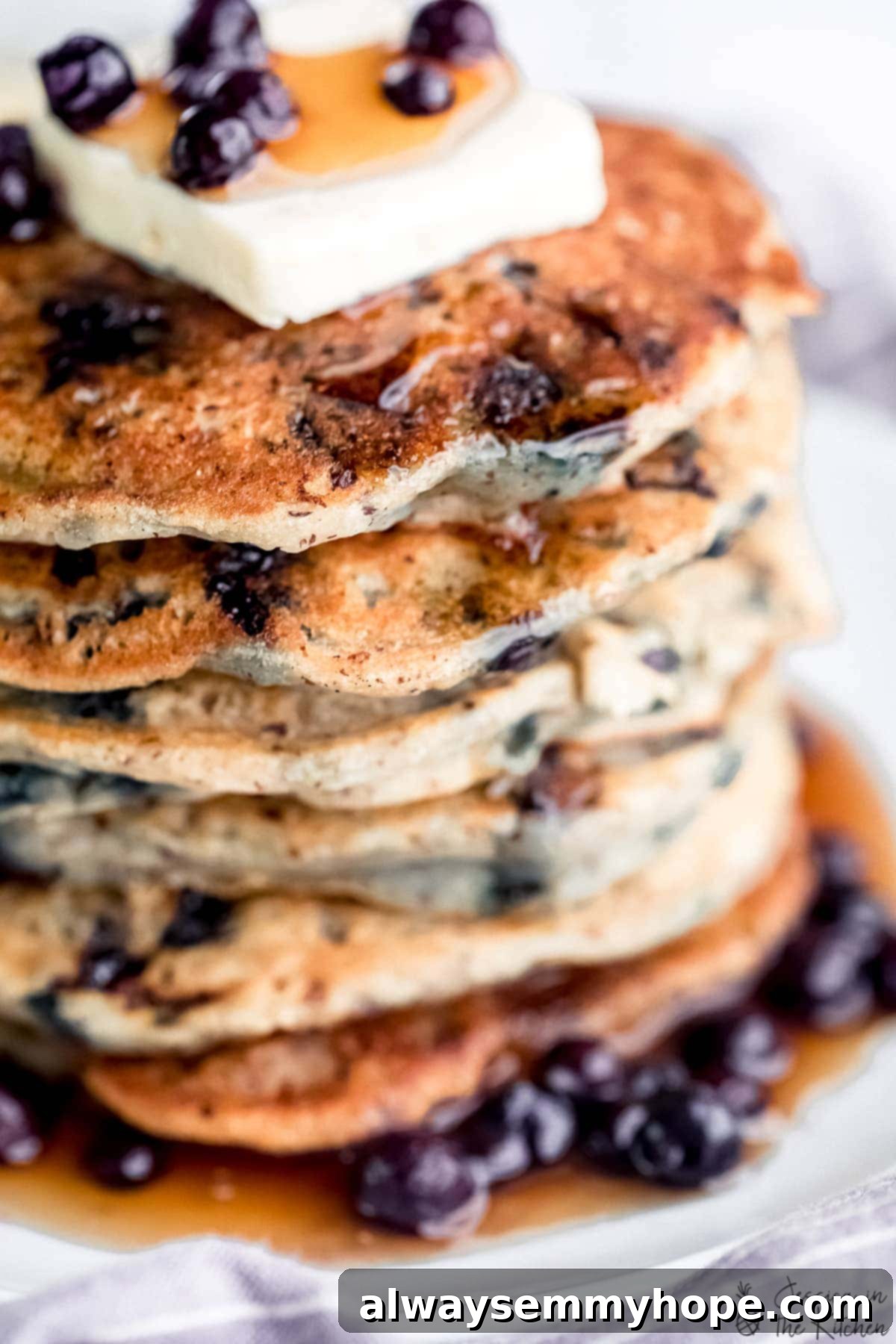 A close-up view of a beautifully cooked, golden-brown fluffy vegan blueberry pancake, ready for toppings.