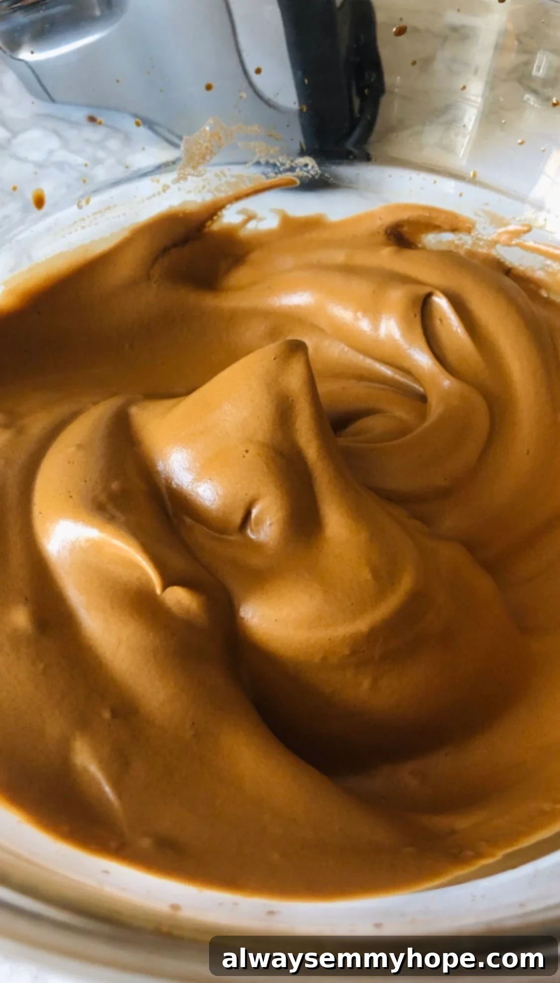 Dalgona Kahve Nasıl Yapılır Püf Noktalarıyla 4 A close-up, top-down shot of whipped coffee in a clear glass bowl, showcasing its light, airy texture and a distinct peak, ready to be served.