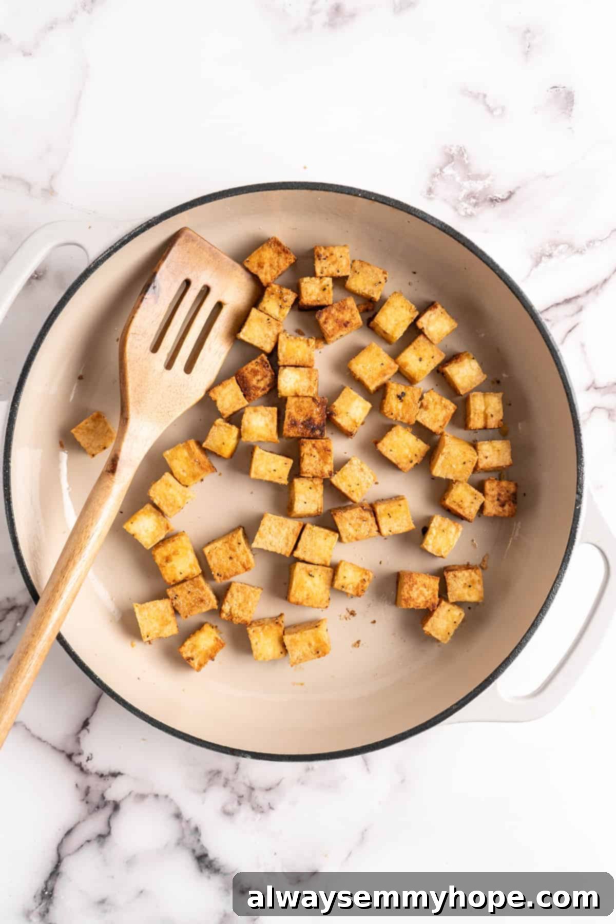Cooked crispy tofu browning in a pan