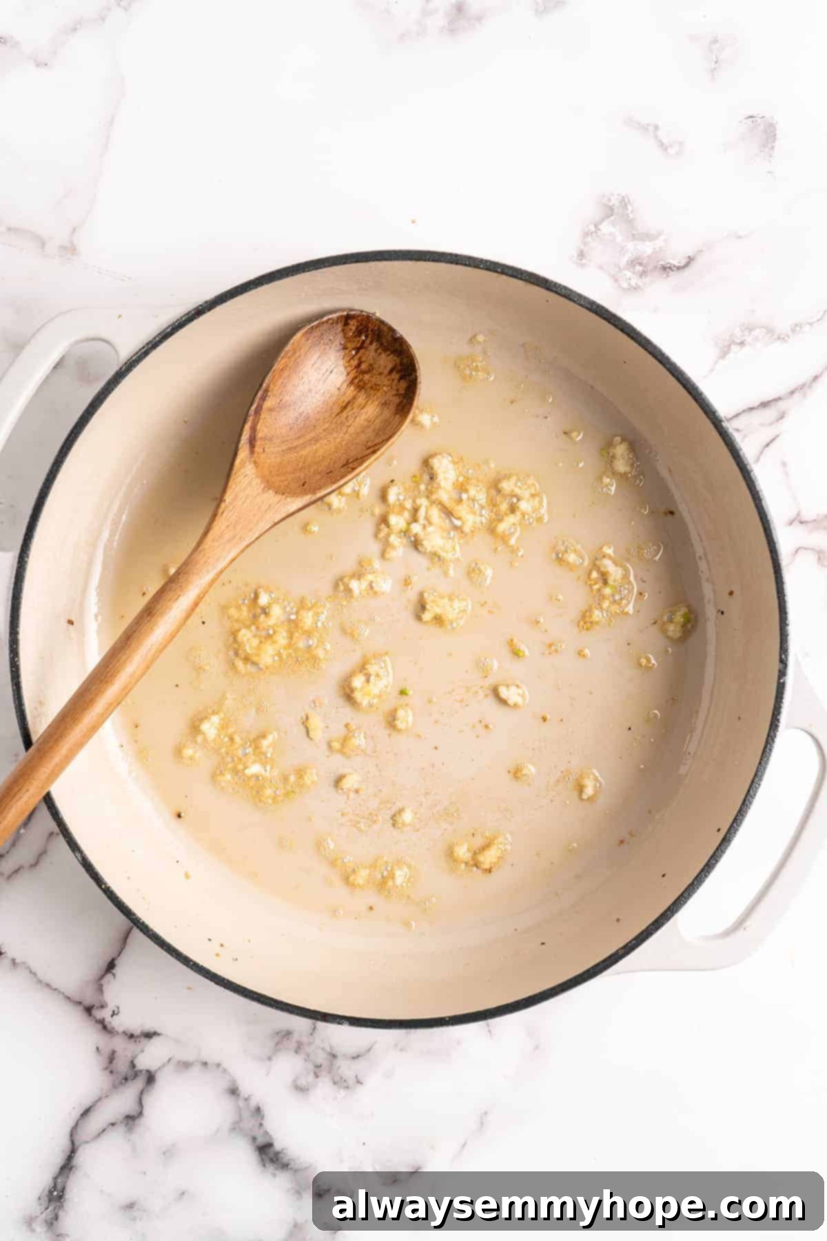 Garlic and ginger cooking in sesame oil in a pan