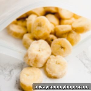 Frozen banana slices coming out of a ziplock bag, ready to be used.