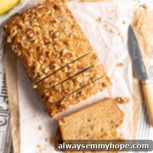 Overhead view of sliced loaf of banana bread set on parchment paper