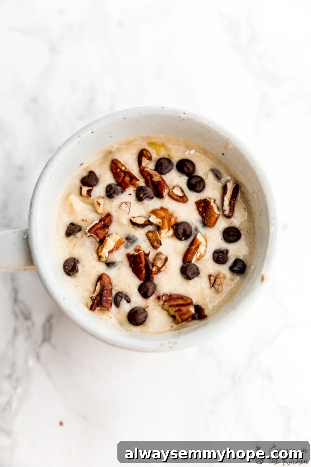 An overhead view of the smooth, golden batter for a banana bread mug cake, perfectly mixed and ready to be microwaved in a sturdy coffee mug.