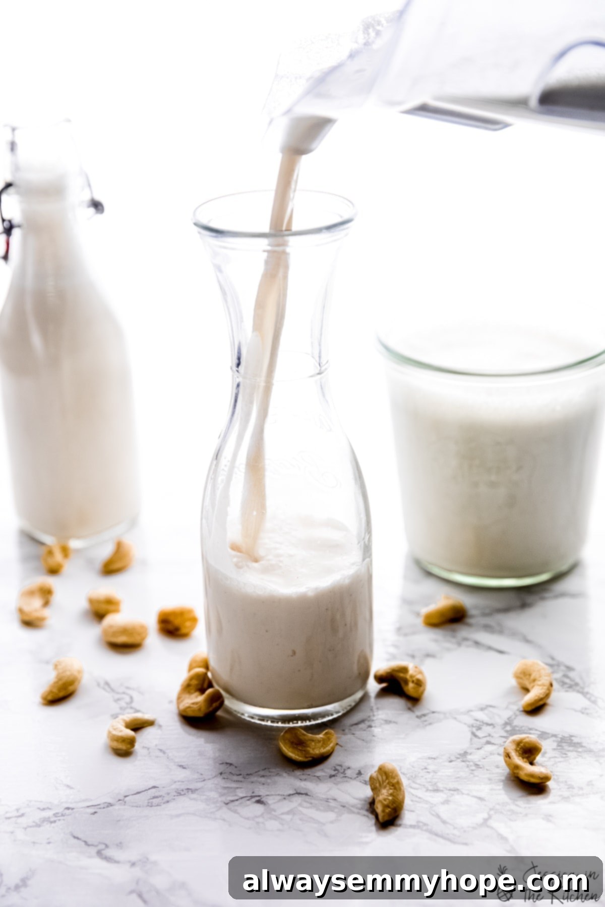Pouring creamy cashew nut milk into a glass bottle, ready for storage in the refrigerator.