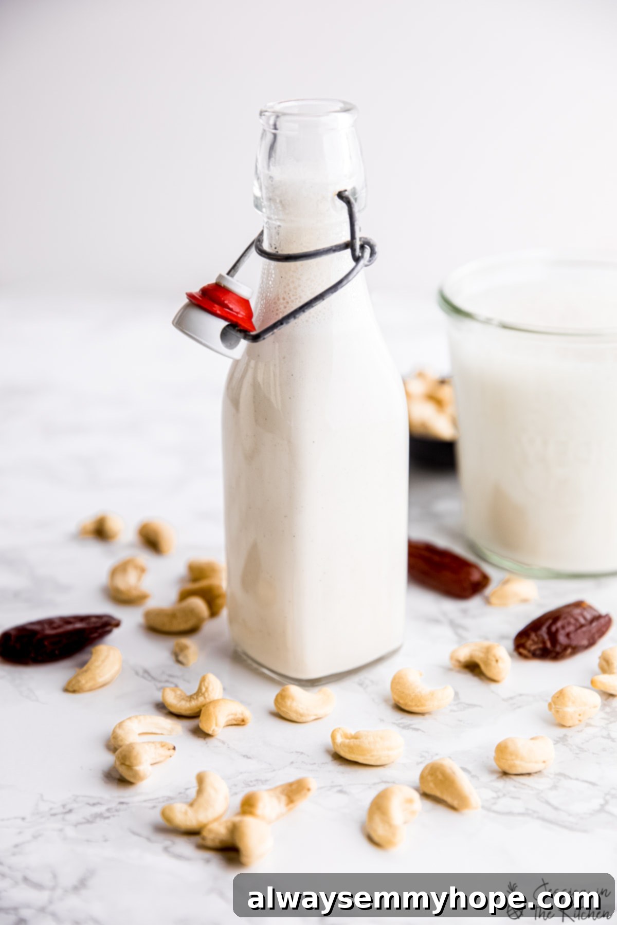 A glass bottle filled with freshly made, creamy homemade cashew milk, ready for refrigeration.