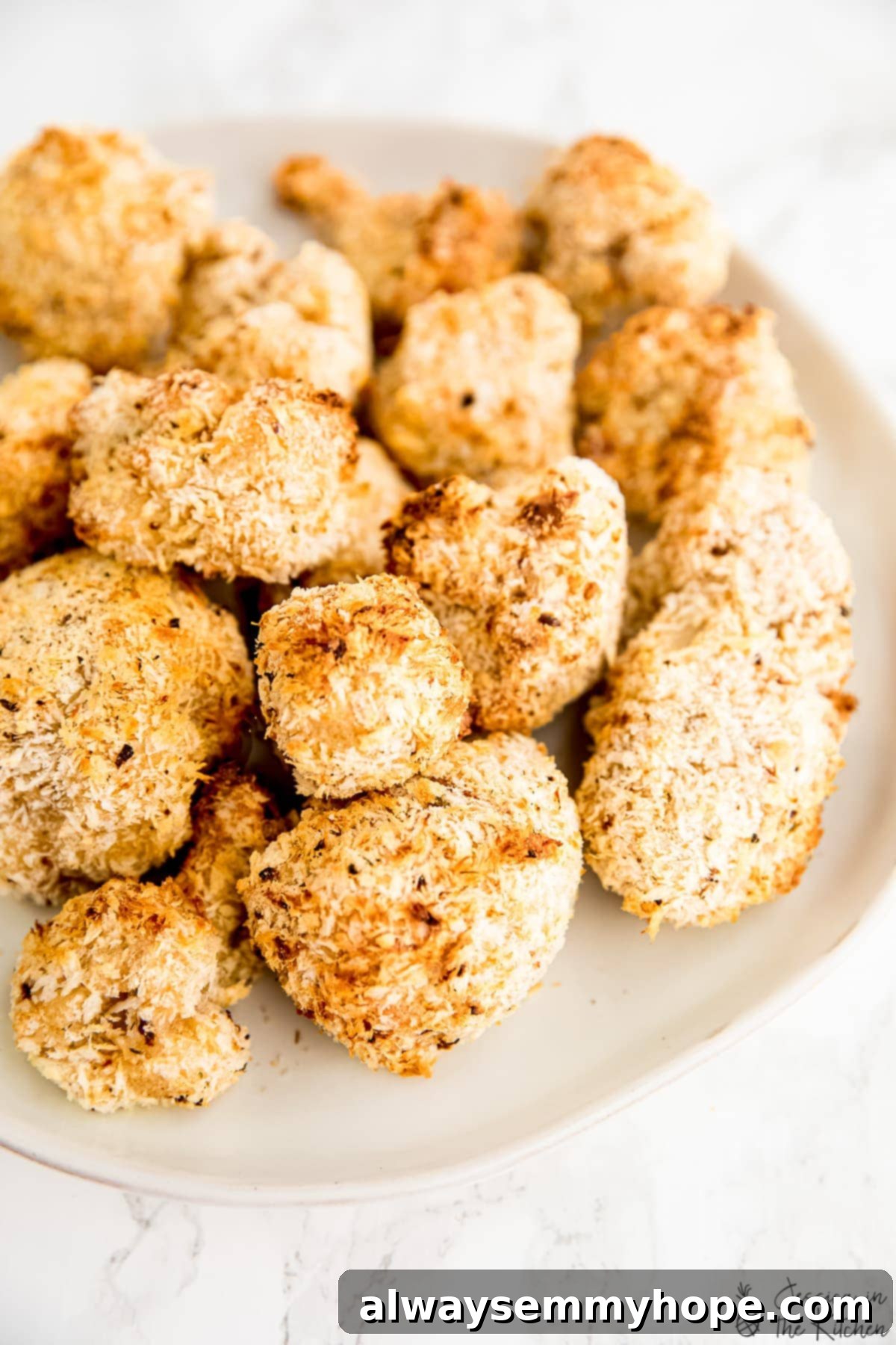 Breaded and baked cauliflower wings on a plate, ready to be sauced.