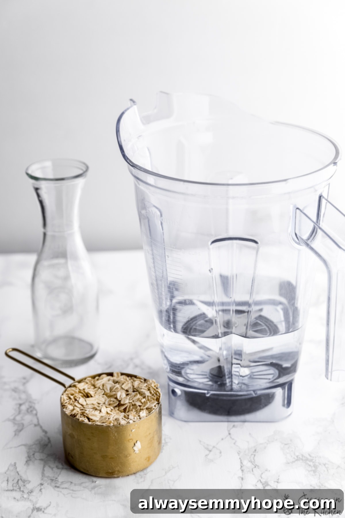 Prepare to make rich, creamy, and delicious oat milk at home with this easy recipe, showing ingredients like rolled oats, a blender, and a storage jar. A measuring cup filled with rolled oats, alongside a high-speed blender and an empty glass jar, ready for making homemade oat milk.