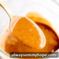 Creamy Thai Peanut Sauce 6 Thai peanut sauce in a gold spoon over a jar.