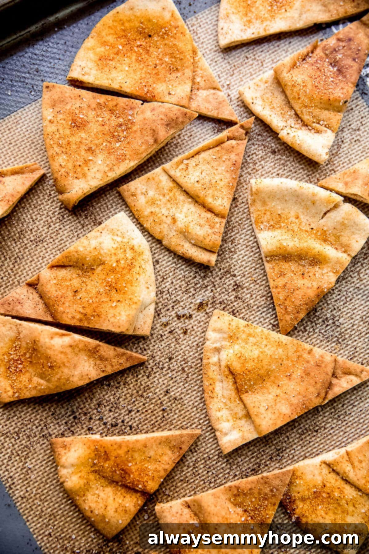 Crispy homemade pita chips cooling on a baking sheet after being perfectly baked.